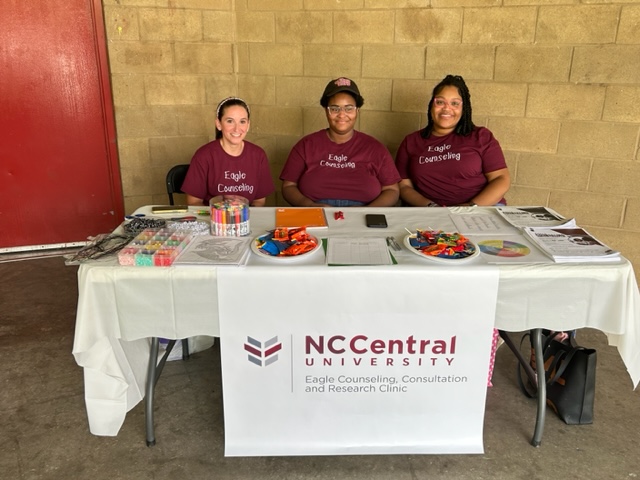 Picture of three students at the table at the event