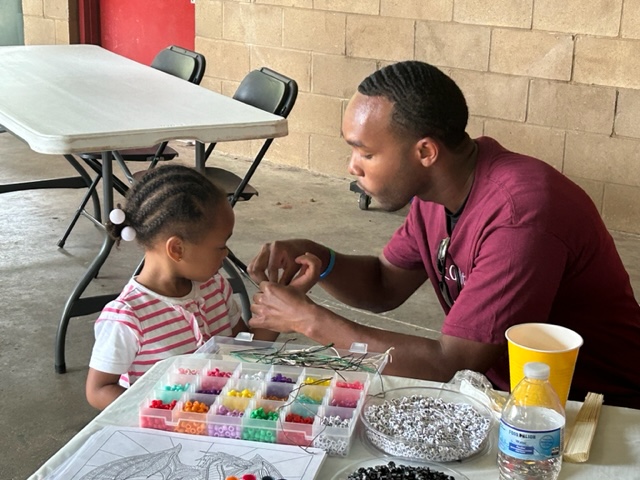 NCCU student with a young visitor at the table